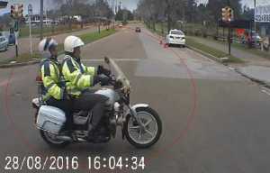 Este es el momento que la moto del cuerpo inspectivo cruza la avenida Roosevelt con semáforo en "rojo".